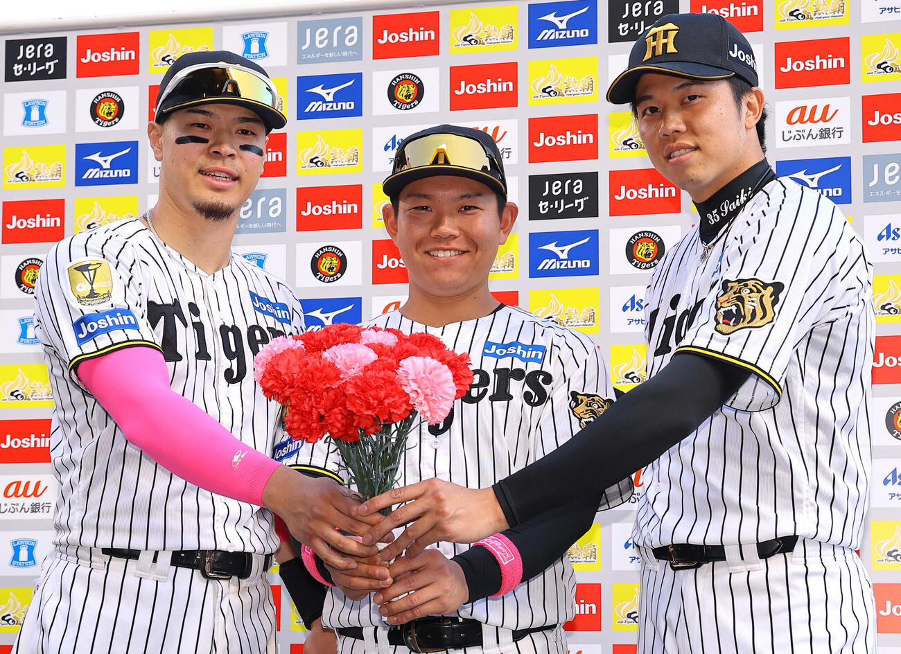 阪神対DeNA　カーネーションを手に笑顔を見せる左から佐藤輝明、嶋村麟士朗、才木浩人（撮影・上田博志）