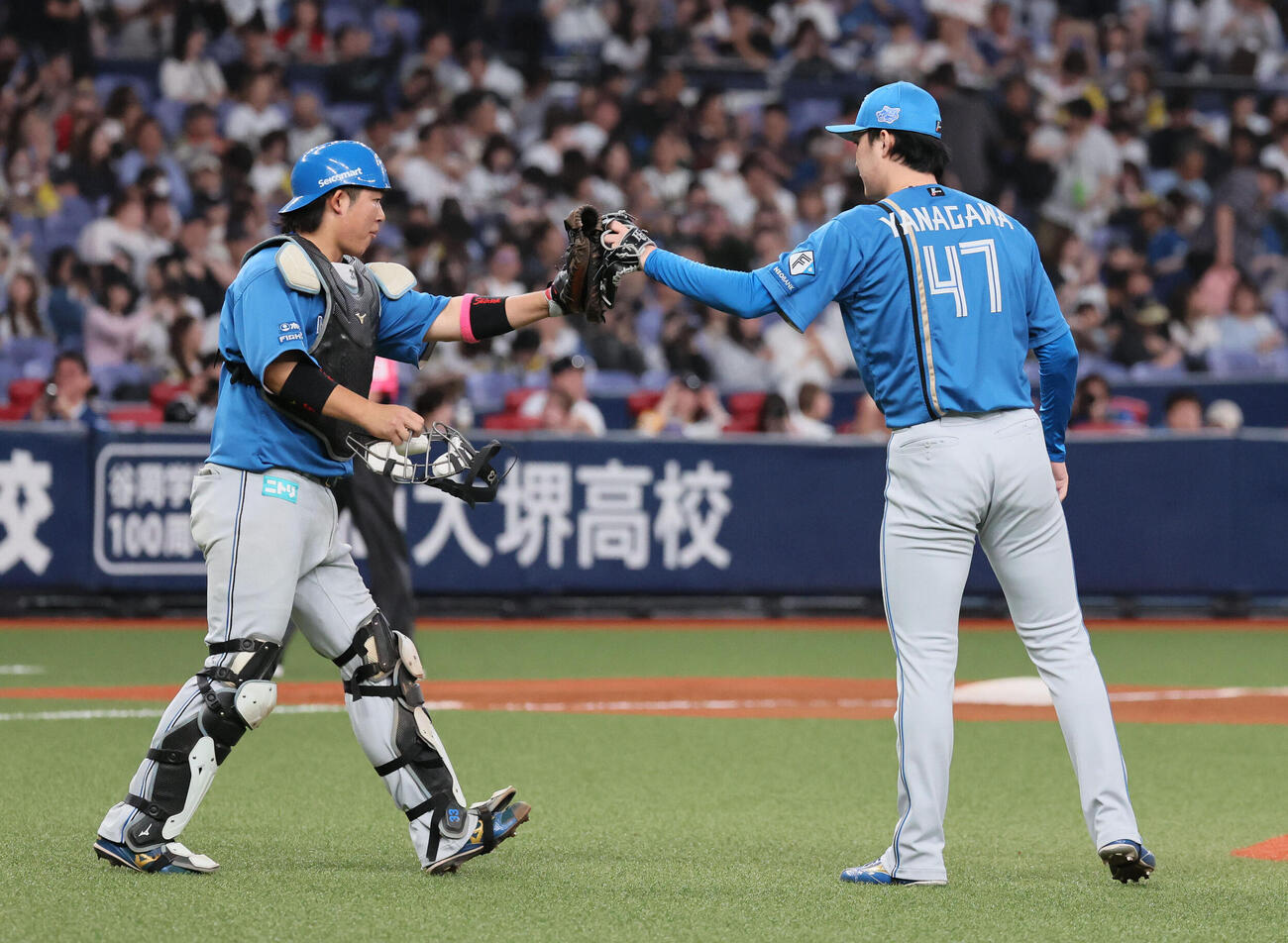 オリックス対日本ハム　最後を締めた日本ハム柳川大晟（右）は進藤勇也とタッチする（撮影・宮崎幸一）