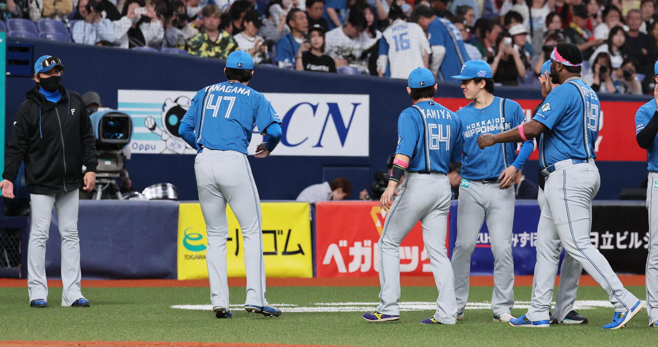 オリックス対日本ハム　3勝目を挙げた日本ハム進藤勇也（左から4人目）は柳川大晟（同2人目）から勝利球を受け取ろうとするが落ちてしまい、そのまま柳川大晟が拾って持って行ってしまう。左端は新庄剛志監督（撮影・宮崎幸一）