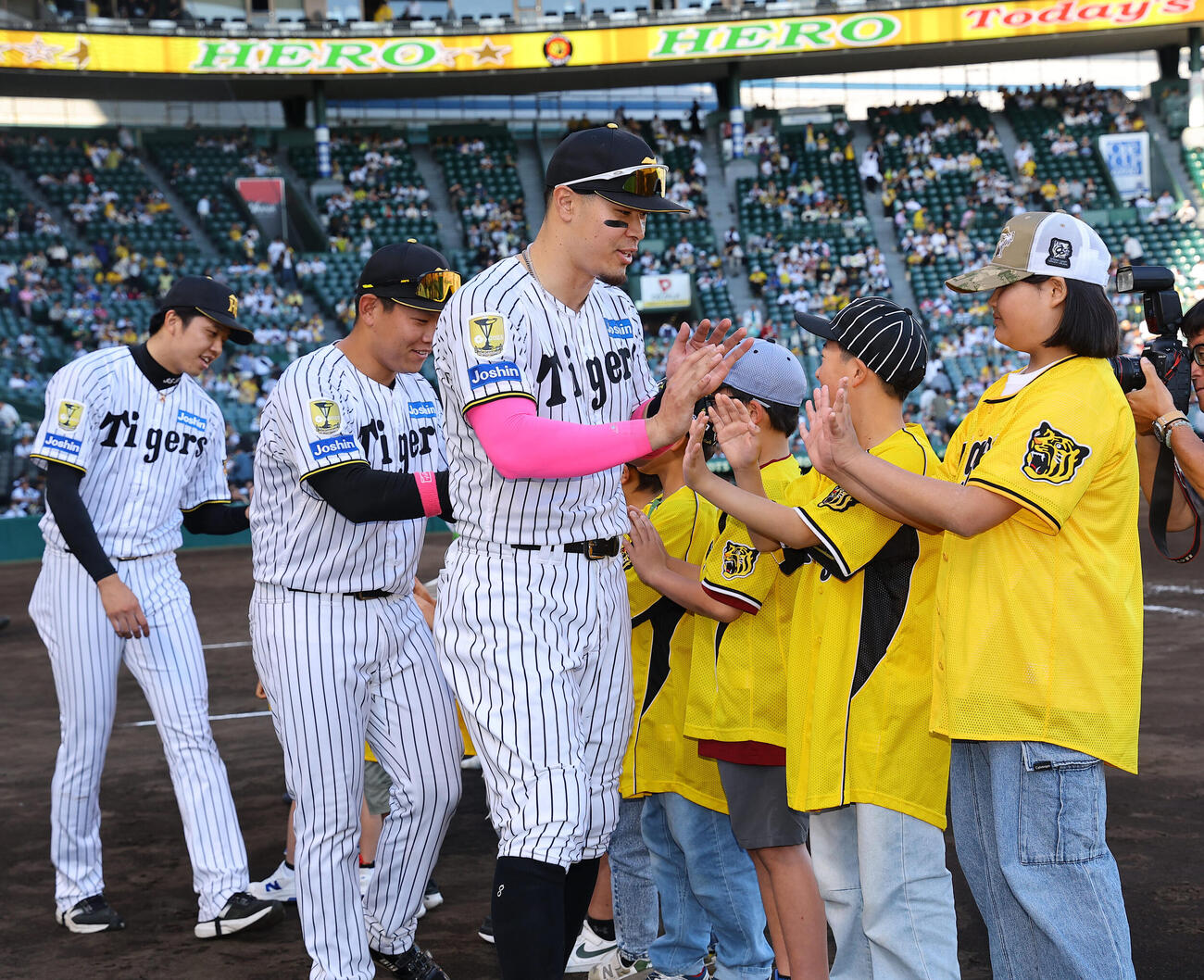 阪神対DeNA　ファンとハイタッチする右から佐藤輝明、嶋村麟士朗、才木浩人（撮影・上田博志）