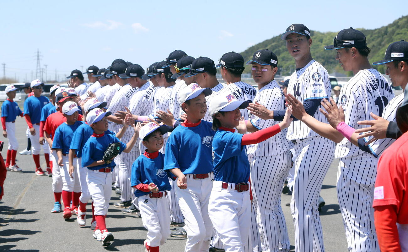 試合後に子供たちとハイタッチする日本製紙石巻の選手ら
