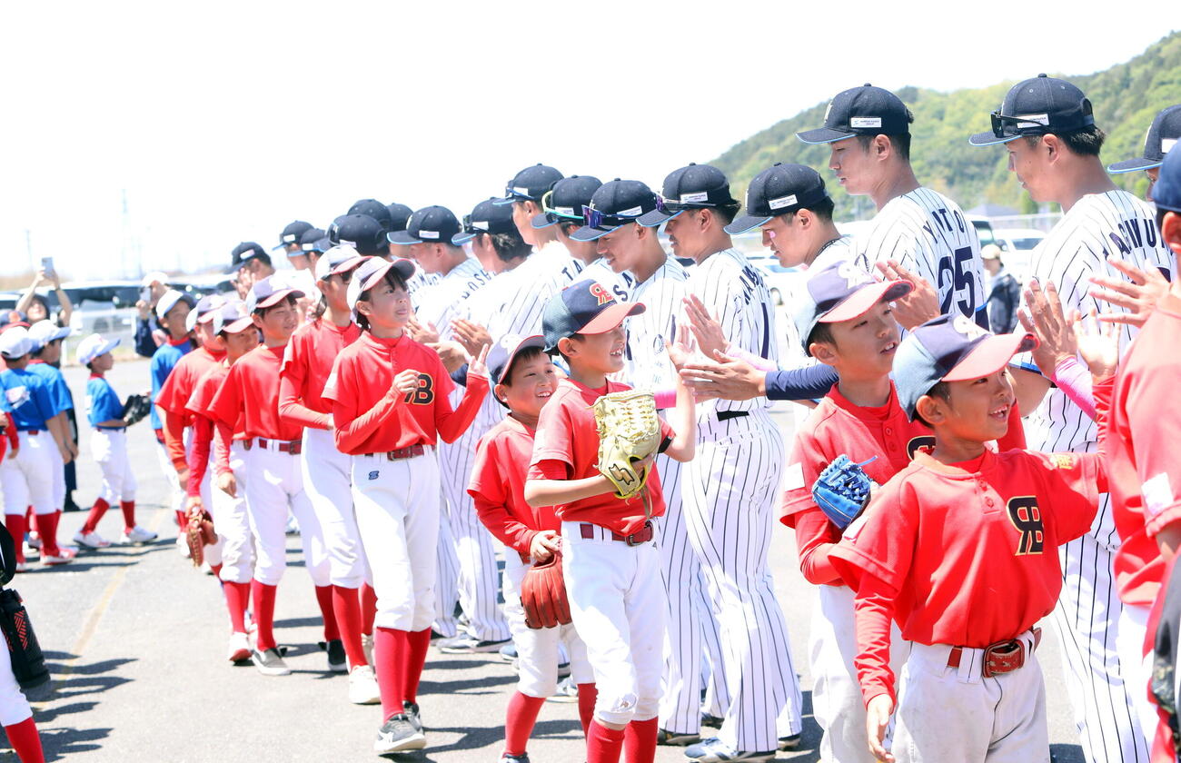 試合後に子供たちとハイタッチする日本製紙石巻の選手ら