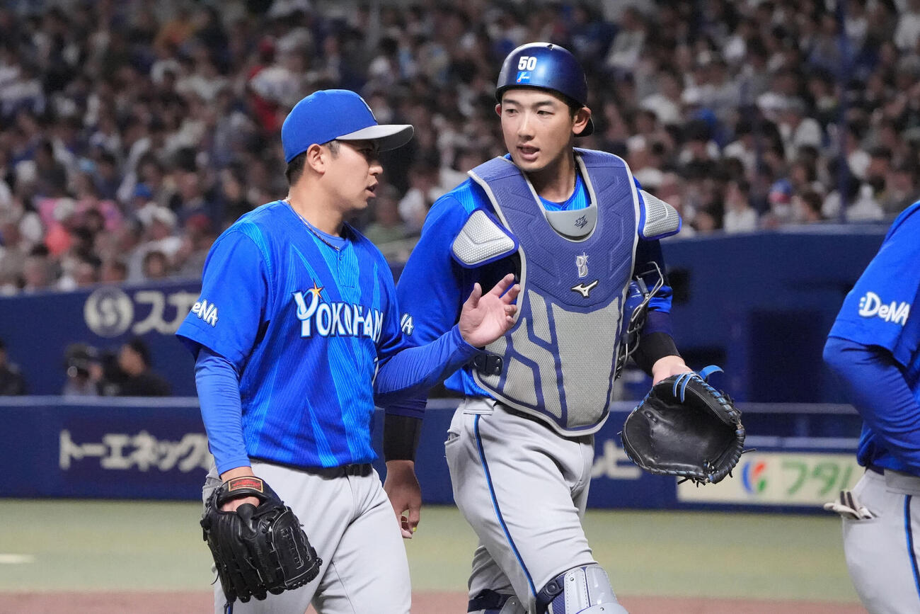 4月28日、中日戦の2回、東克樹（左）と言葉を交わしながらベンチに戻るDeNA山本祐大