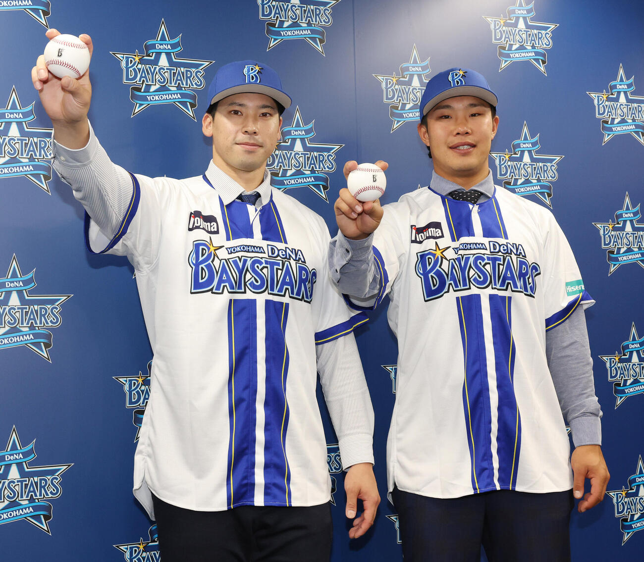 ソフトバンクからトレードでDeNAに入団し、笑顔でボールを握る尾形崇斗（左）と井上朋也（撮影・宮地輝）