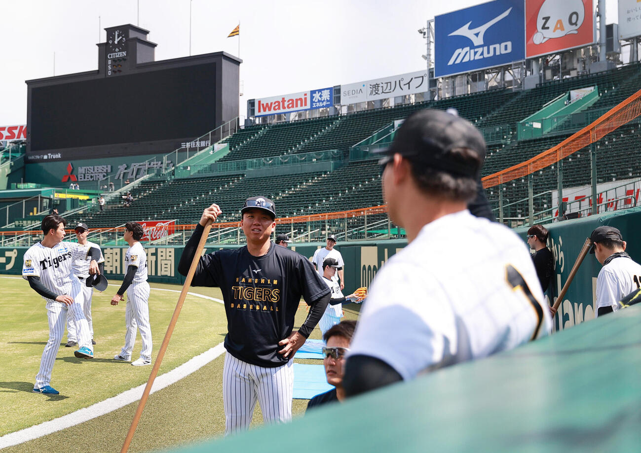 甲子園の外野フェンス沿いで森下翔太（手前）と言葉を交わす阪神村上頌樹（撮影・上山淳一）
