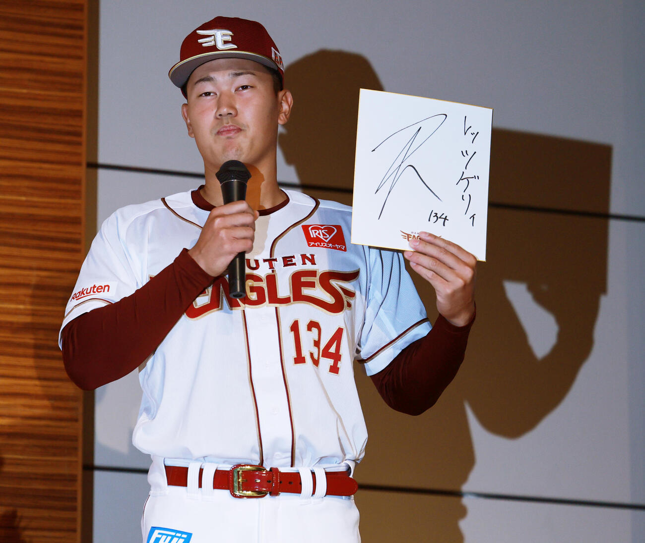 25年12月5日、楽天新入団選手発表会見で色紙にレッツゲリィと記す楽天育成ドラフト4位の神奈川大・金子（撮影・野上伸悟）
