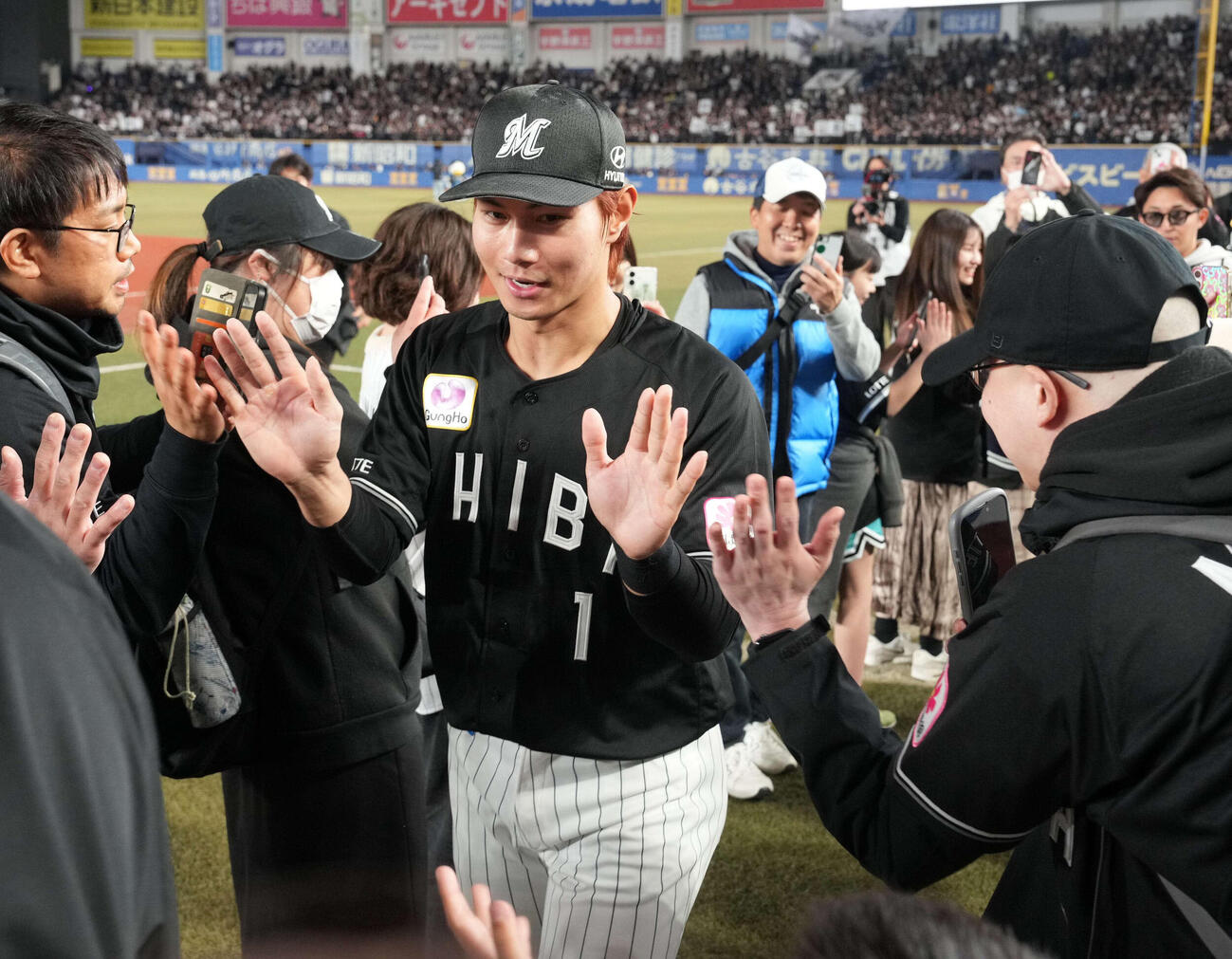 ロッテ対ソフトバンク　サヨナラ打のロッテ藤原は歓喜のファンと勝利のハイタッチに笑顔を見せる（撮影・小沢裕）