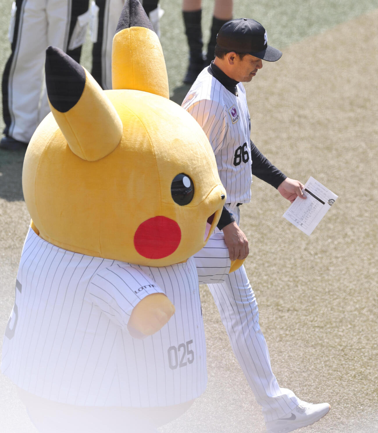 ロッテ対オリックス　メンバー表の最終確認を終え、ピカチュウと手をつなぎベンチに戻るロッテのサブロー監督（撮影・野上伸悟）