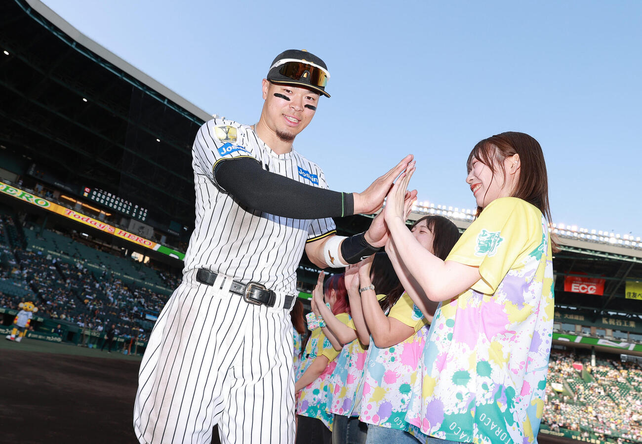 阪神対広島　ヒーローの阪神佐藤輝明はTORACO DAYで選ばれたファンとタッチかわす（撮影・上山淳一）