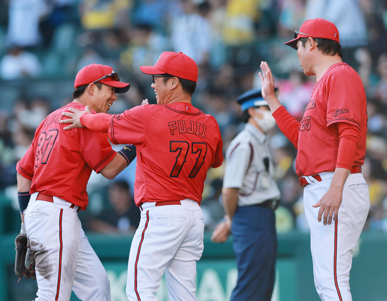 阪神対広島　阪神に勝利した新井貴浩監督（右）はベンチ前で試合を締めた野間峻祥を出迎える。中央は藤井彰人ヘッドコーチ（撮影・上山淳一）