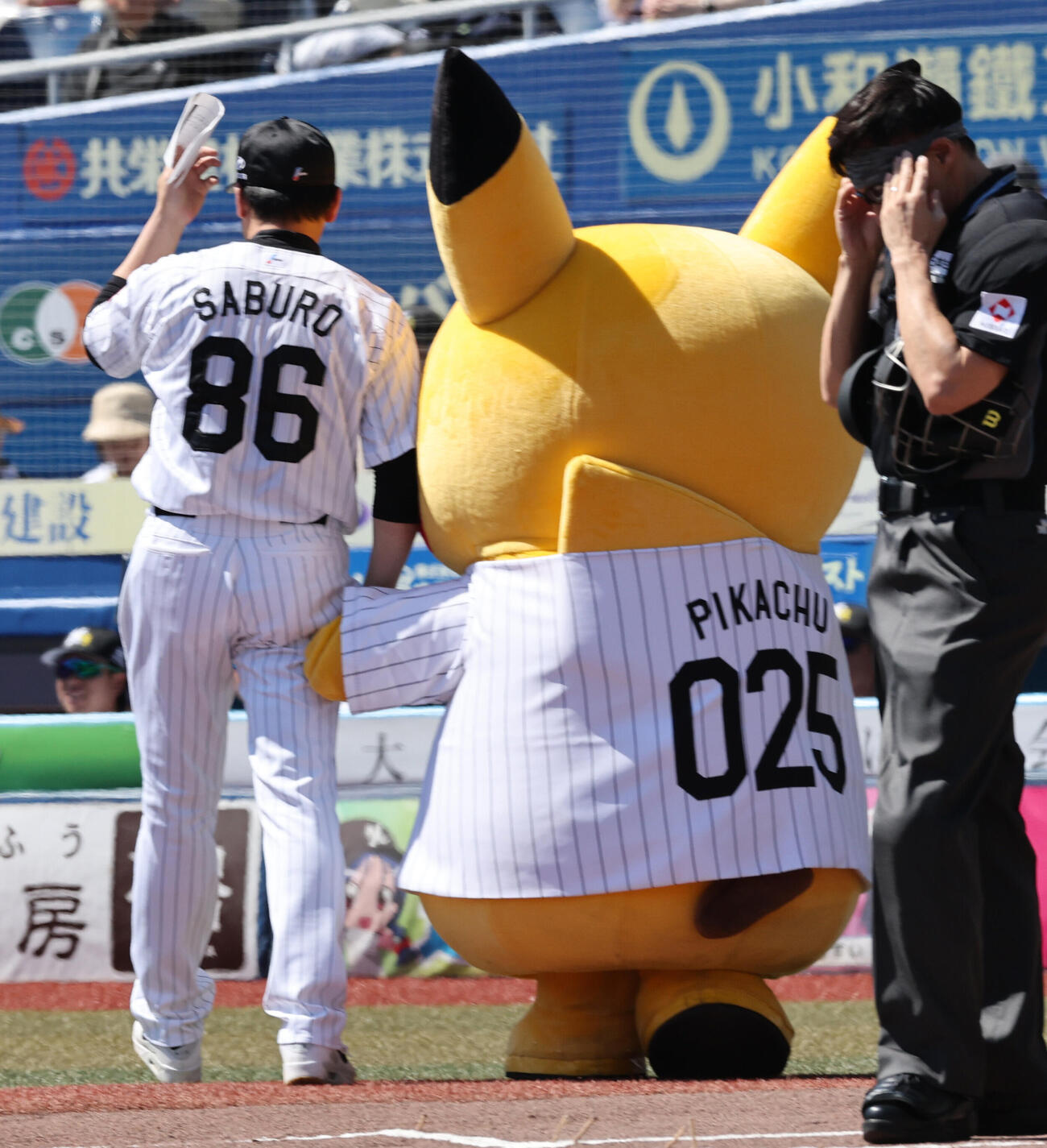ロッテ対オリックス　メンバー表の最終確認を終え、ピカチュウと手をつなぎベンチに戻るロッテのサブロー監督（撮影・野上伸悟）