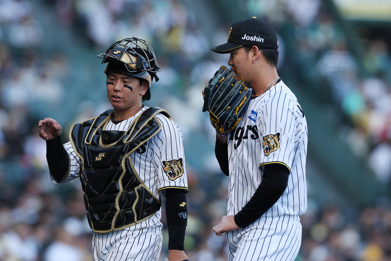 阪神対広島　8回表を終え言葉を交わしてベンチへ戻る阪神梅野隆太郎（左）と及川雅貴（撮影・前田充）