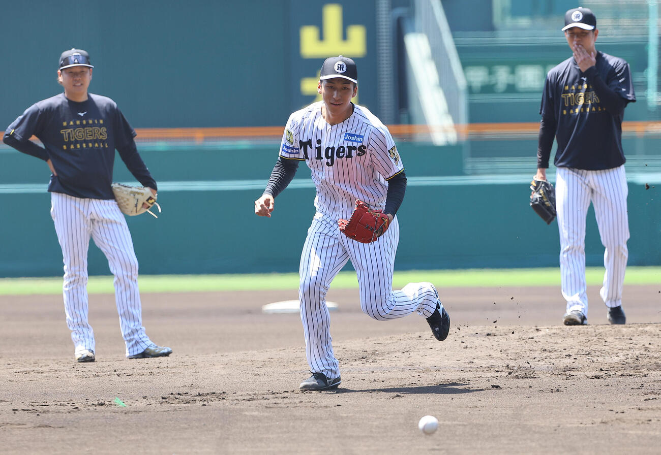 茨木秀俊（中央）は西勇輝（左）高橋遥人と投内連係プレーの練習をする（撮影・上田博志）