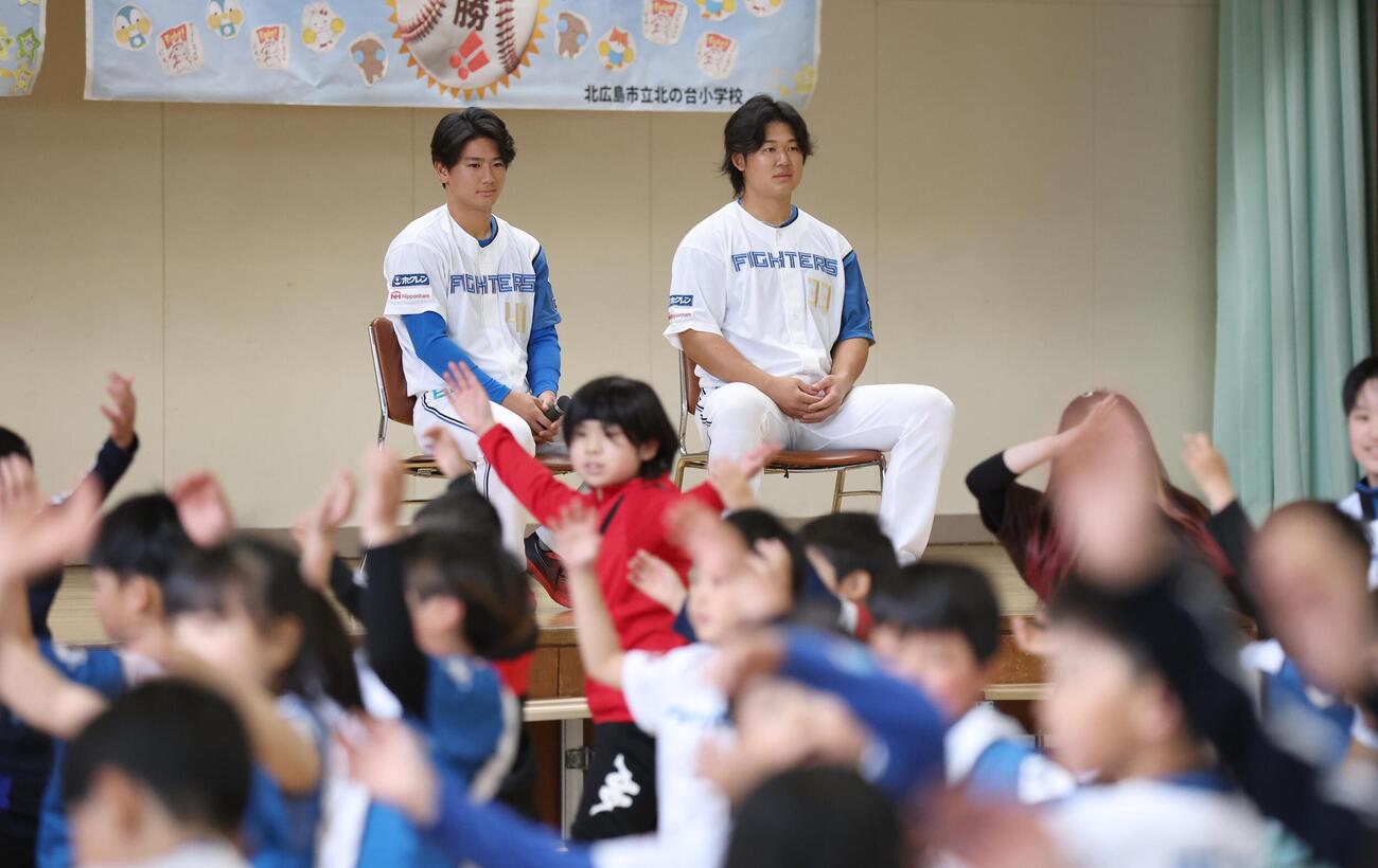 北広島市内の小学校で児童の踊りを見る大塚瑠晏（左）と進藤勇也（撮影・黒川智章）