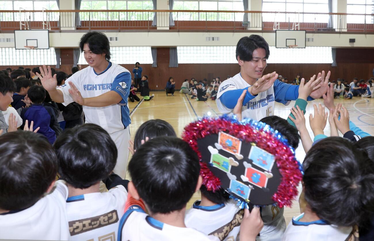 北広島市内の小学校で児童とハイタッチする大塚瑠晏（右）と進藤勇也（撮影・黒川智章）