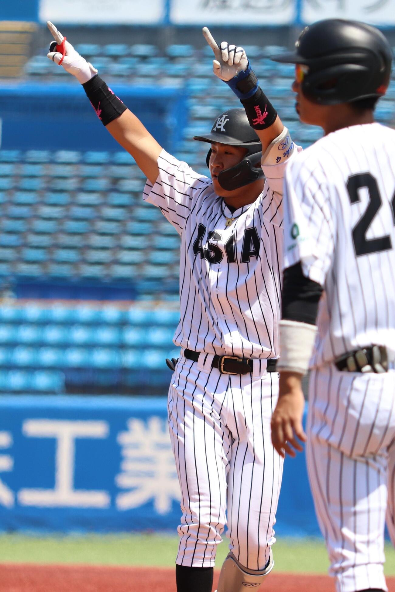 東都大学野球春季リーグ　亜大対立正大　5回表亜大2死満塁、2点適時打を放ち、塁上で喜ぶ小池祐吏（左）（撮影・服部航大）