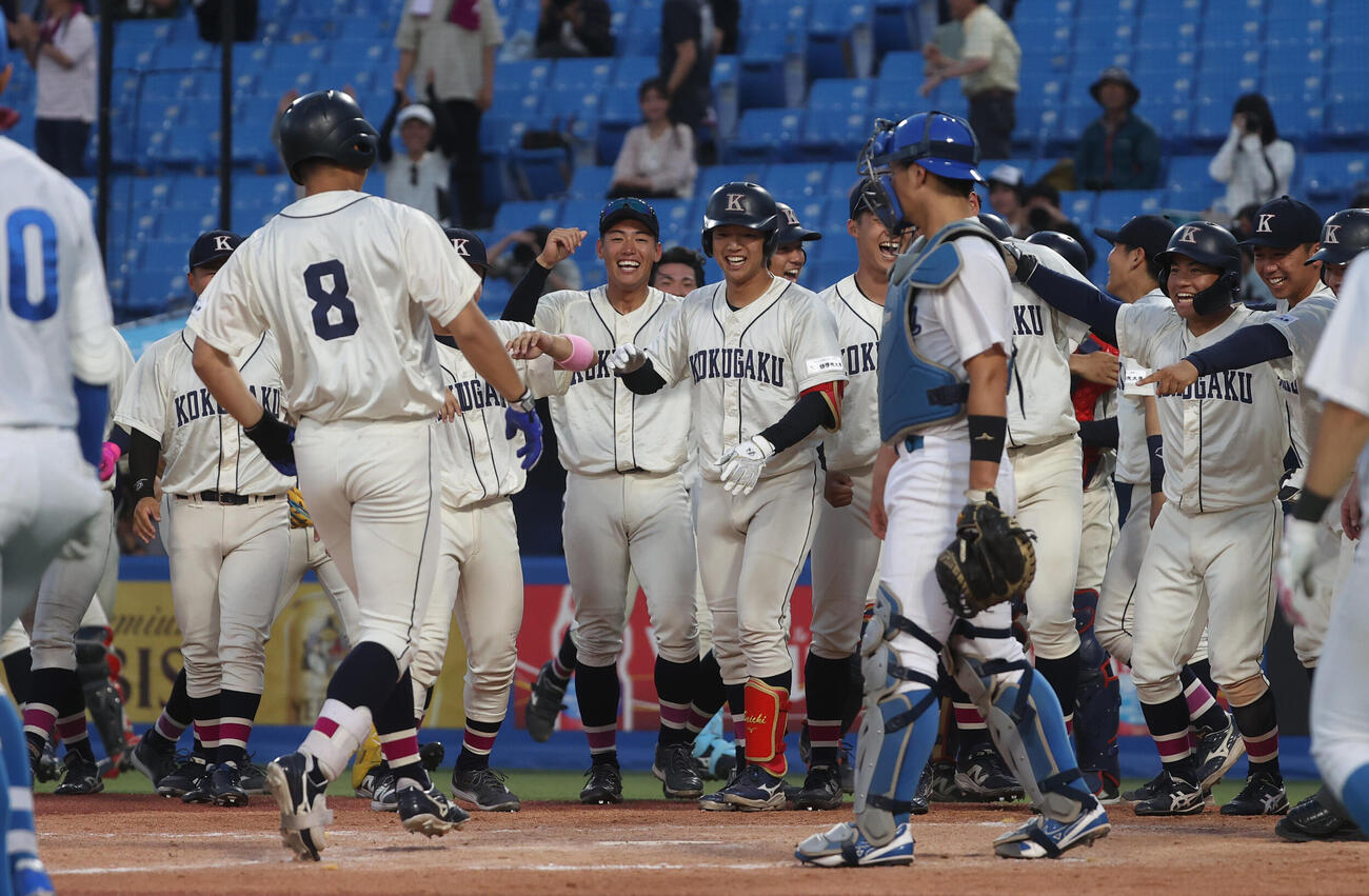 青学大対国学院大　タイブレーク10回裏国学院大2死一、二塁、サヨナラ本塁打を放った大谷汰一を出迎える国学院大ナイン（撮影・柴田隆二）