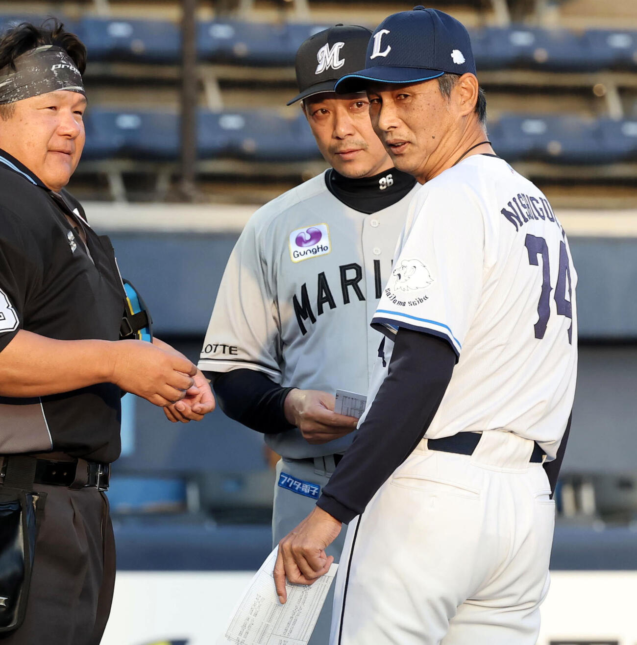 西武対ロッテ　メンバー最終確認で、球審の説明を聞く西武西口文也監督（手前）とロッテサブロー監督（撮影・浅見桂子）