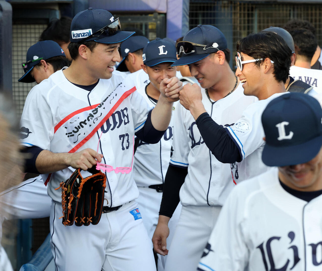 西武対ロッテ　試合前円陣の声出しで、この日誕生日の西武林安可（左）と佐藤太陽は笑顔でグータッチ（撮影・浅見桂子）