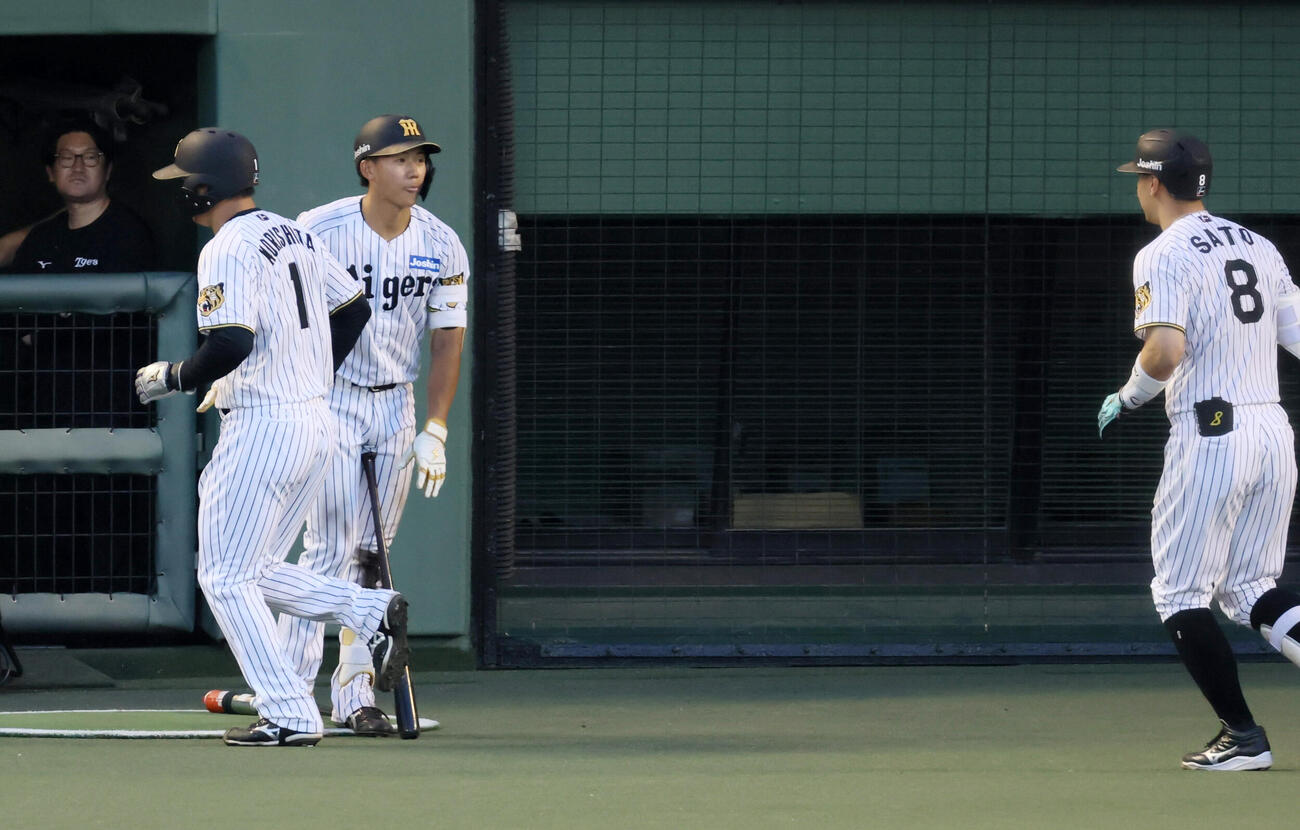 阪神対中日　3回裏阪神1死一塁、佐藤輝明（右）の右中間越え2点本塁打を迎える立石正広。左は森下翔太（撮影・加藤哉）