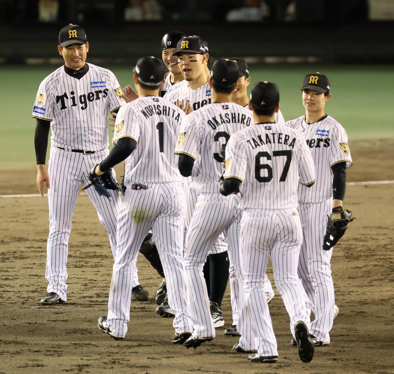 阪神対中日　中日に勝利しナインとタッチする阪神岩崎優（左端）。中央は佐藤輝明（撮影・加藤哉）