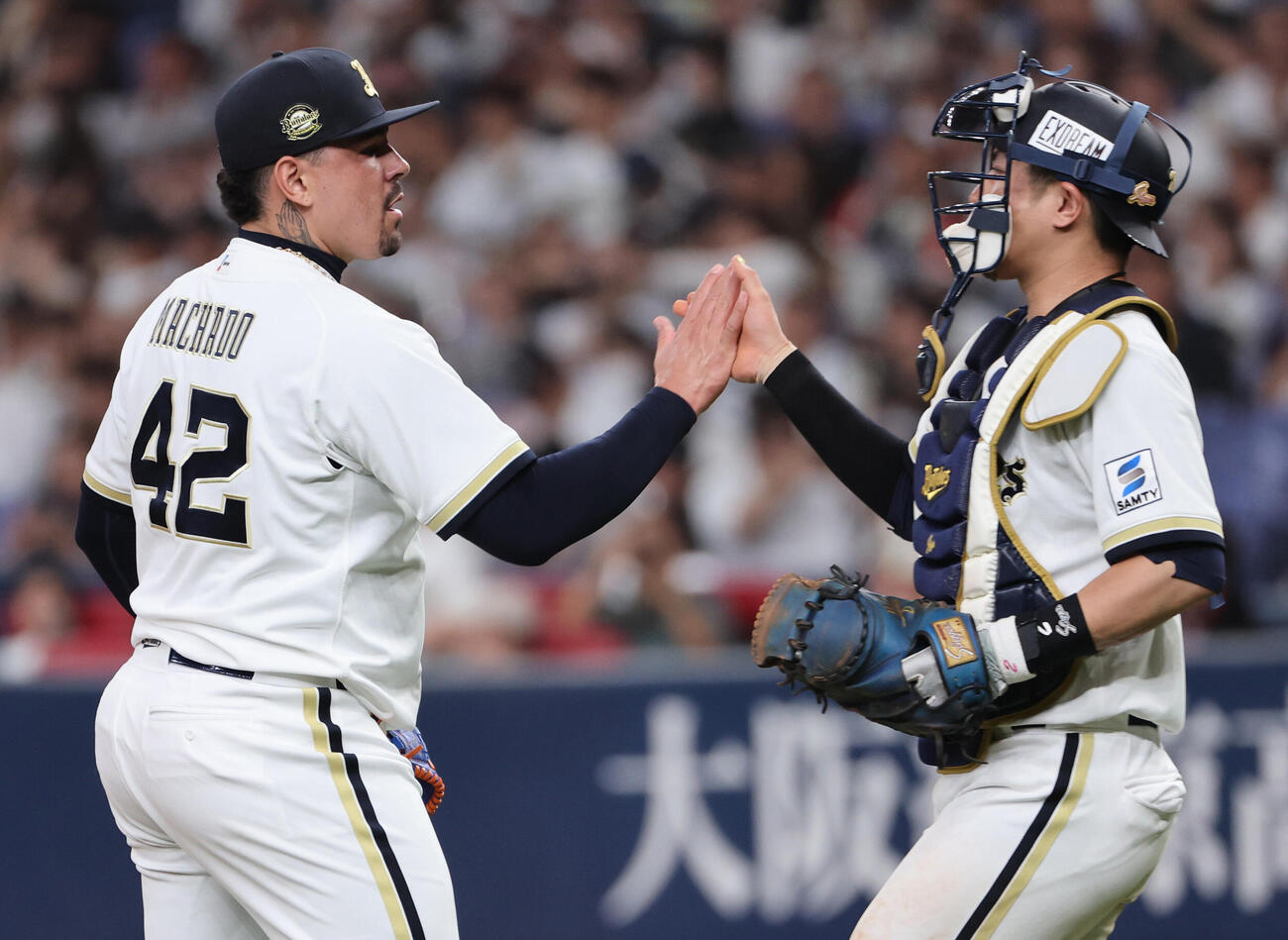 オリックス対ソフトバンク　セーブを挙げたオリックスのアンドレス・マチャドは若月健矢とタッチをかわす（撮影・西尾就之）
