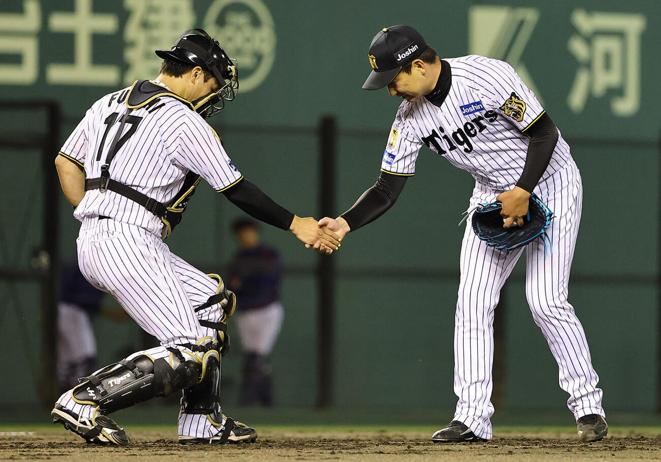阪神対中日　中日に勝利し伏見寅威（左）と握手を交わす岩崎優（撮影・上田博志）