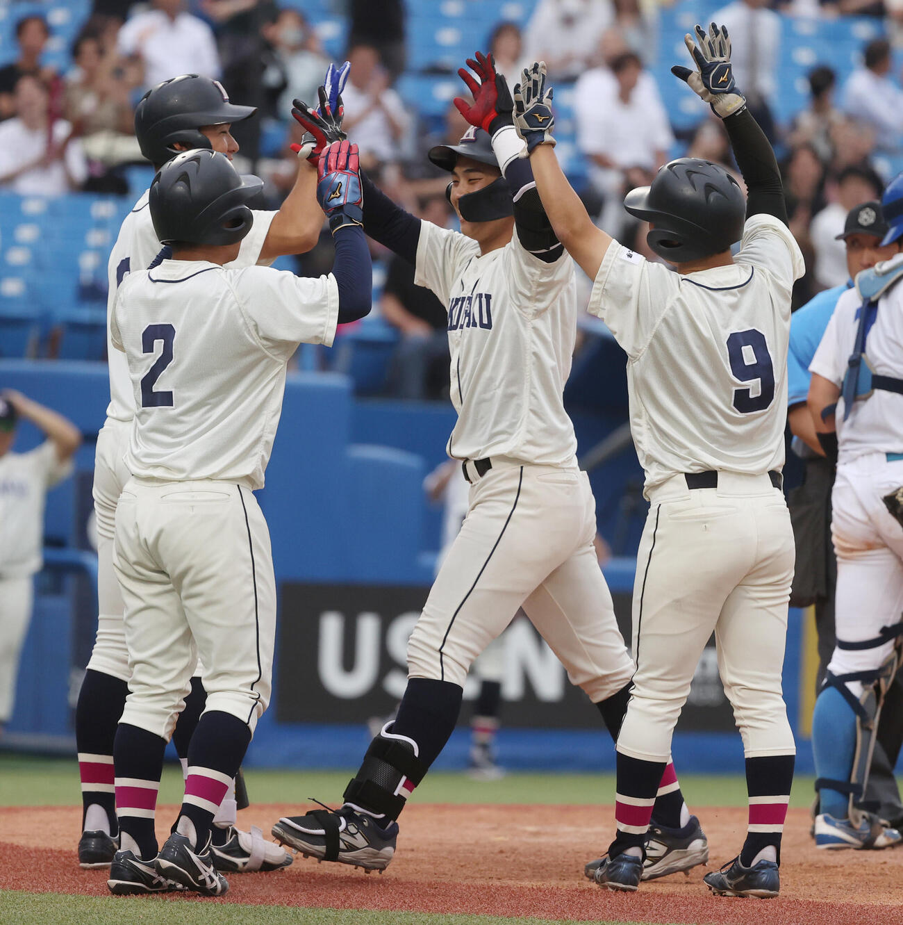 東都大学野球　国学院大対青学大　5回表国学院大1死満塁、石野蓮授(中央)は満塁本塁打を放ちナインとハイタッチする（撮影・柴田隆二）