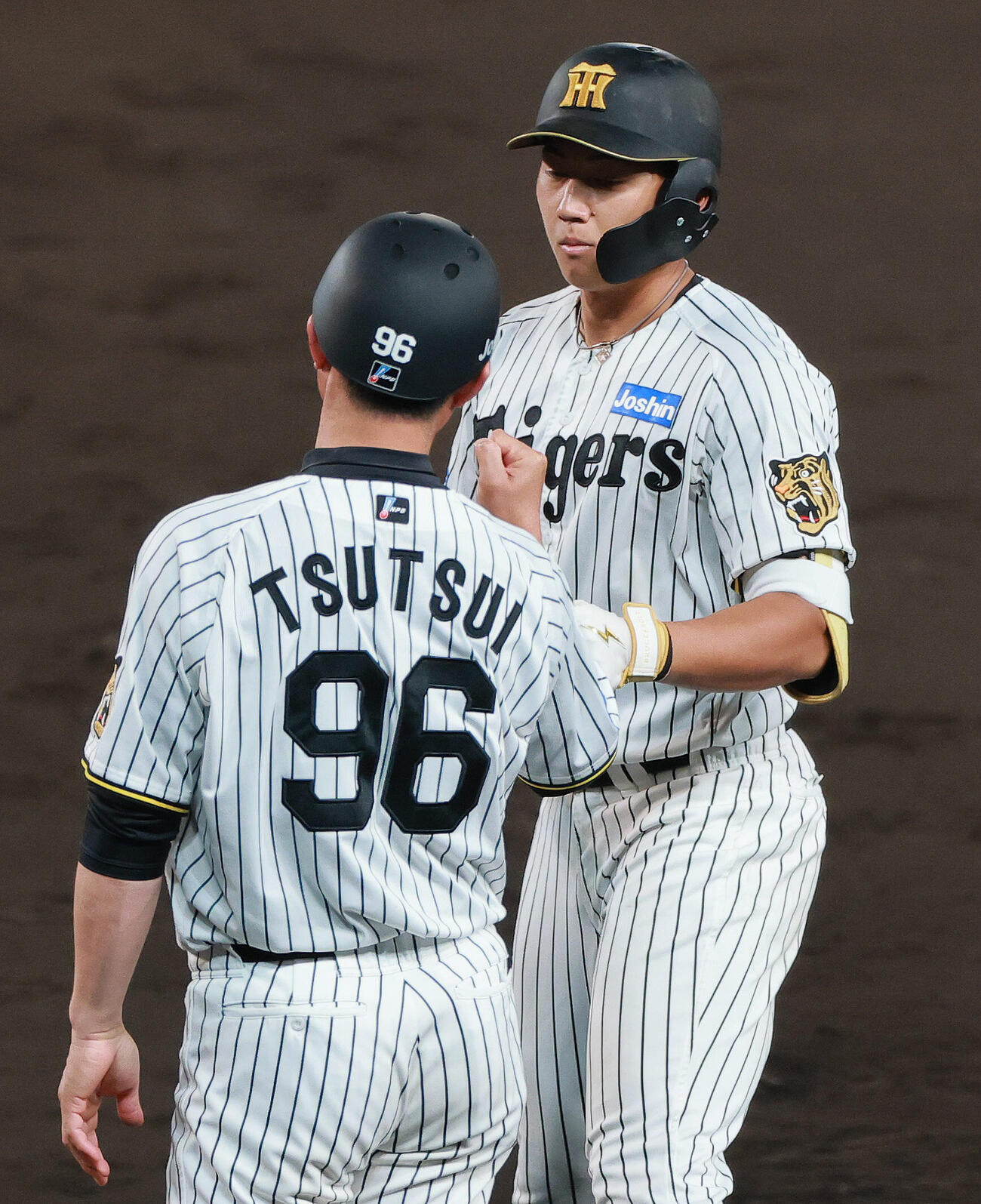 セ・リーグ11回戦　阪神対中日　7回裏阪神1死一塁、立石正広（右）は安打を放ち筒井壮外野守備兼走塁チーフコーチとタッチをかわす（撮影・上山淳一）＝2026年5月20日