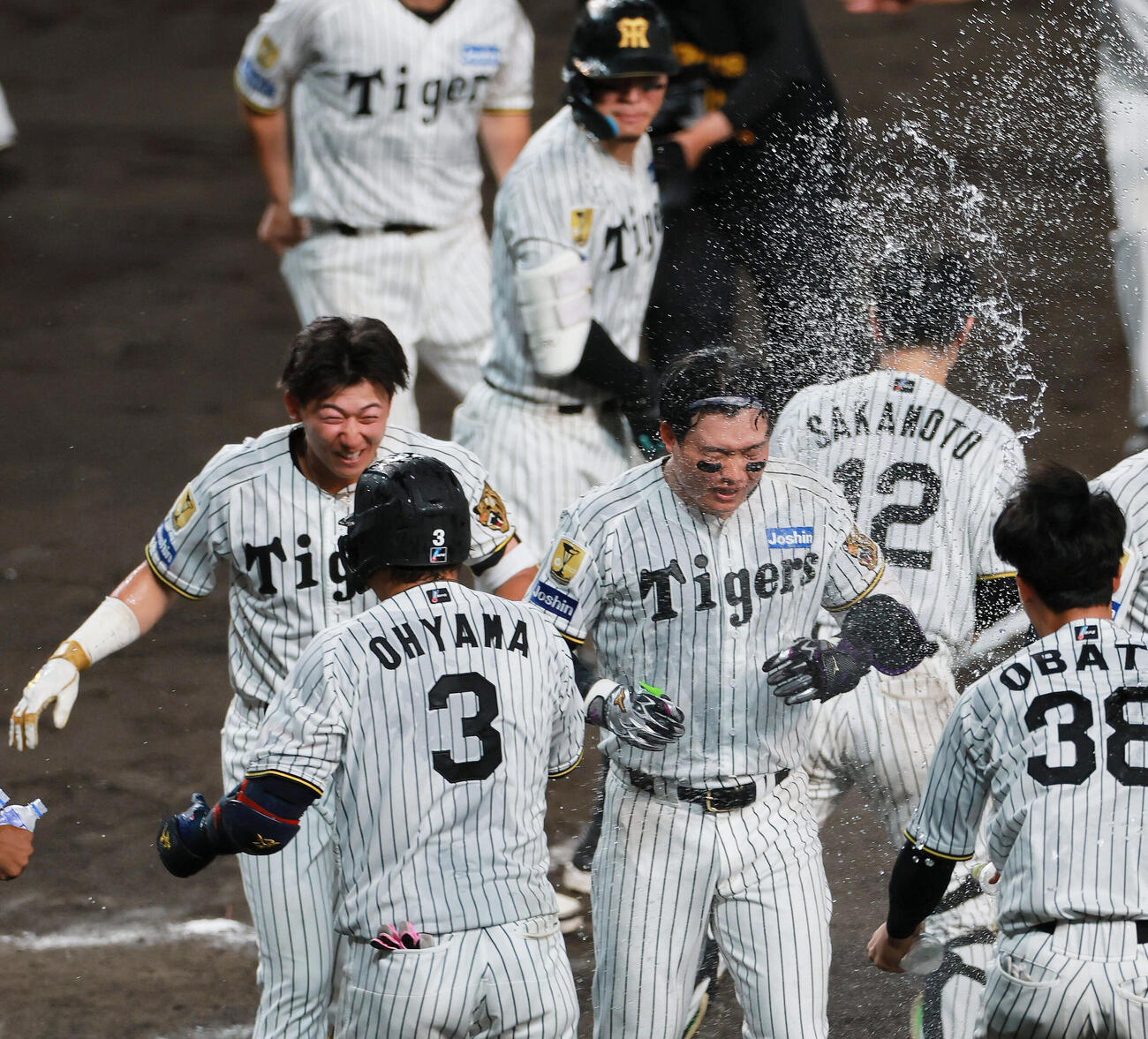 セ・リーグ11回戦　阪神対中日　9回裏阪神無死、森下翔太（右）はサヨナラソロ本塁打を放ち仲間からウオーターシャワーの祝福を受ける。左は立石正広（撮影・上山淳一）＝2026年5月20日