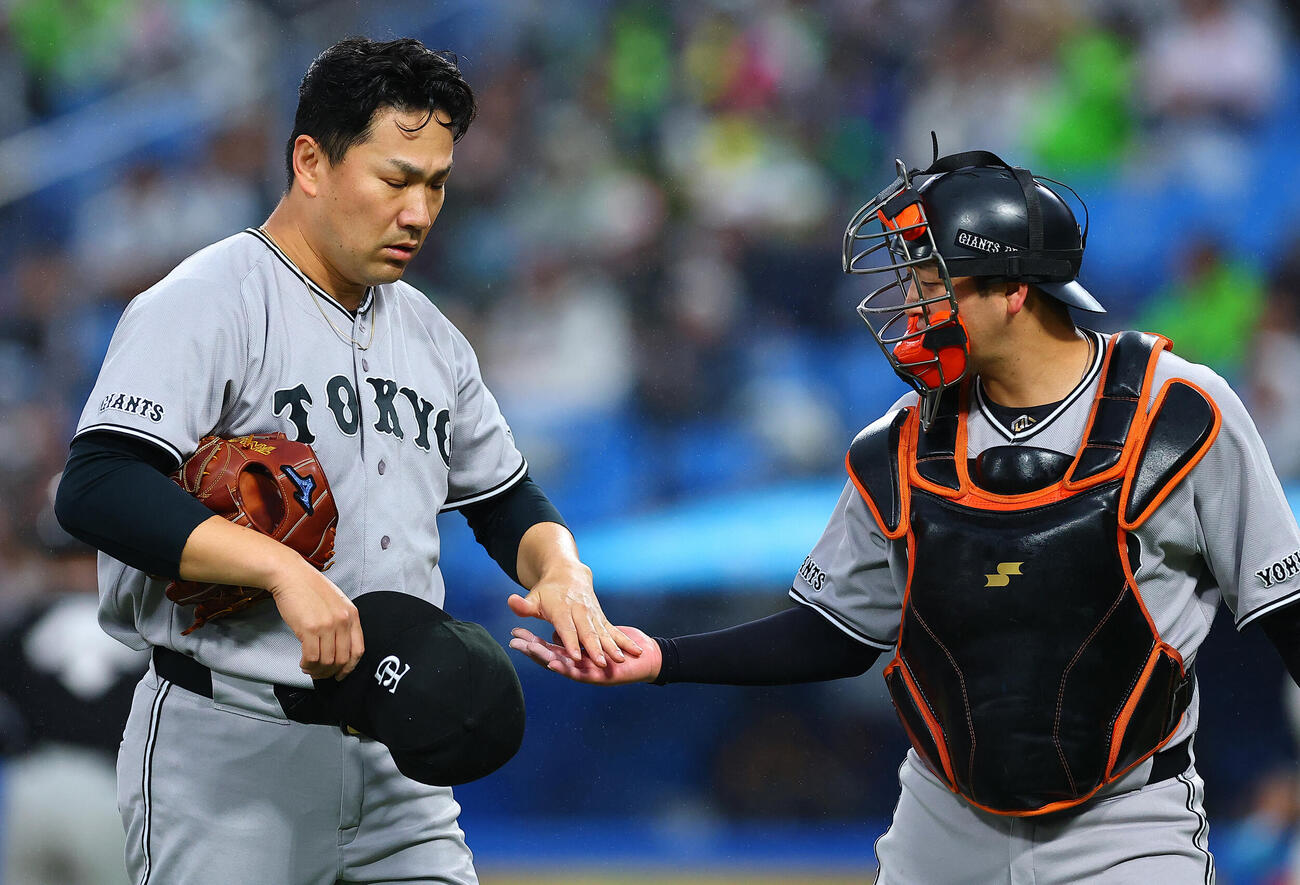 ヤクルト対巨人　1回裏を終え、岸田行倫（右）とタッチしてベンチに戻る巨人先発の田中将大（撮影・野上伸悟）
