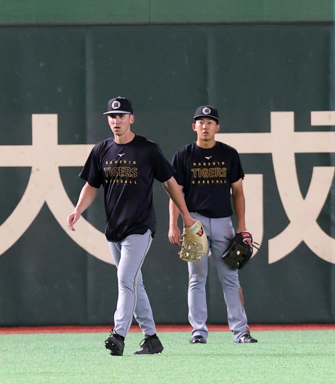 巨人対阪神　フリー打撃中、左翼の守備に入った阪神ティム・ディベイニー（左）。後方は立石正広（撮影・浅見桂子）