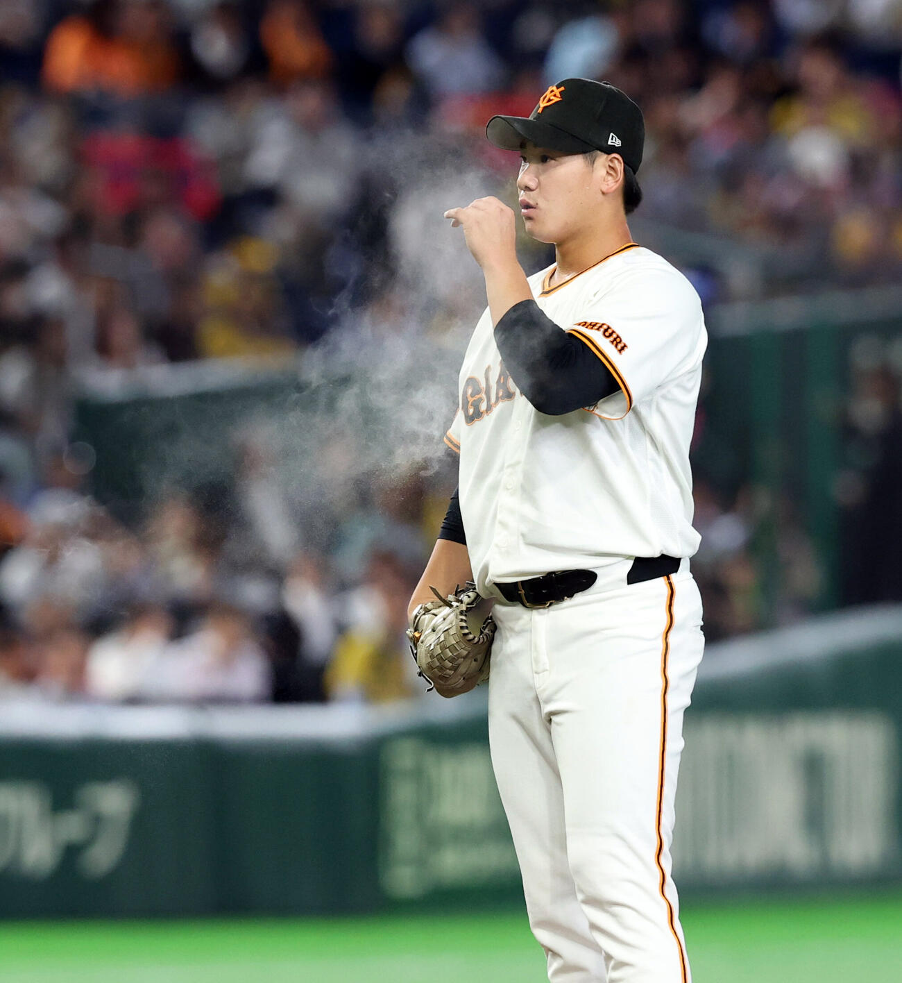 巨人対阪神　投球前、ロージンバッグの粉を吹く巨人先発の井上温大（撮影・浅見桂子）