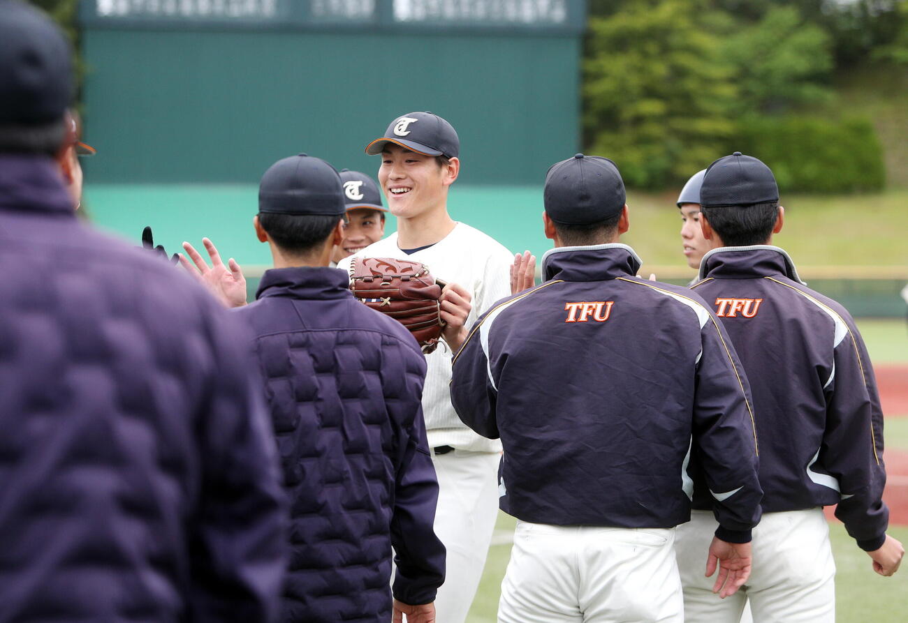 東北福祉大対東北学院大　5回を無失点に終え、ベンチに迎えられる東北福祉大・猪俣駿太（中央)