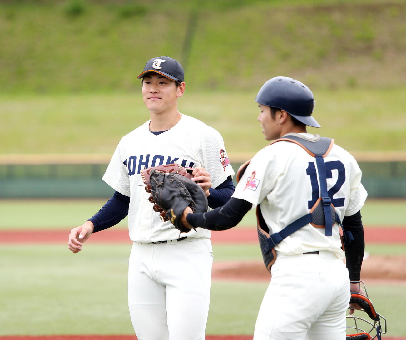 東北福祉大対東北学院大　5回を無失点に終え、グラブタッチする東北福祉大・猪俣駿太（左）