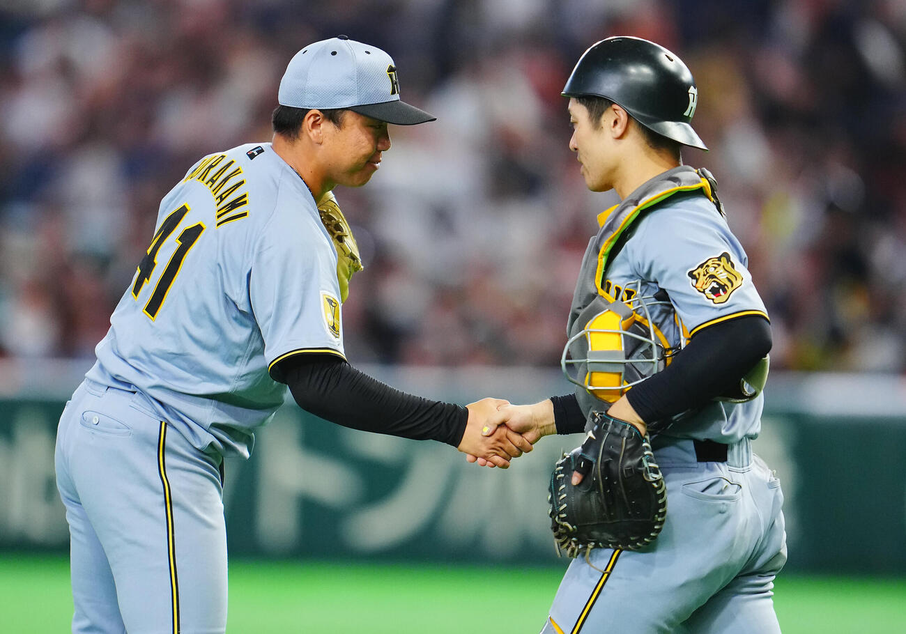 巨人対阪神　9回裏巨人2死一塁、代打増田陸を空振り三振に仕留め完封勝利の村上頌樹（左）は坂本誠志郎と握手を交わす（撮影・垰建太）