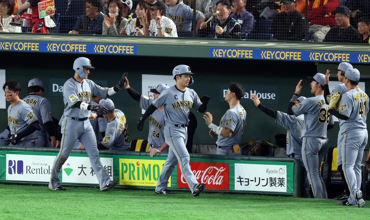 巨人対阪神　5回表阪神2死二、三塁、立石正広の2点適時打で生還した坂本誠志郎（中央）、木浪聖也はナインとハイタッチ（撮影・浅見桂子）