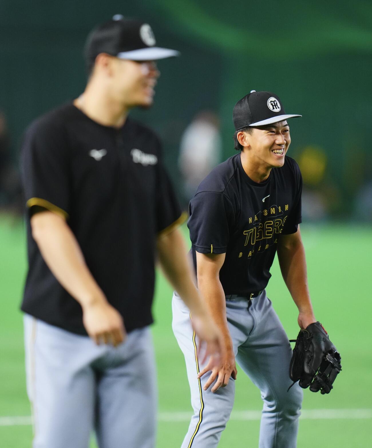 巨人対阪神　試合前、三塁でノックを受ける立石正広（右）は佐藤輝明と笑顔で談笑する（撮影・垰建太）＝2026年5月24日