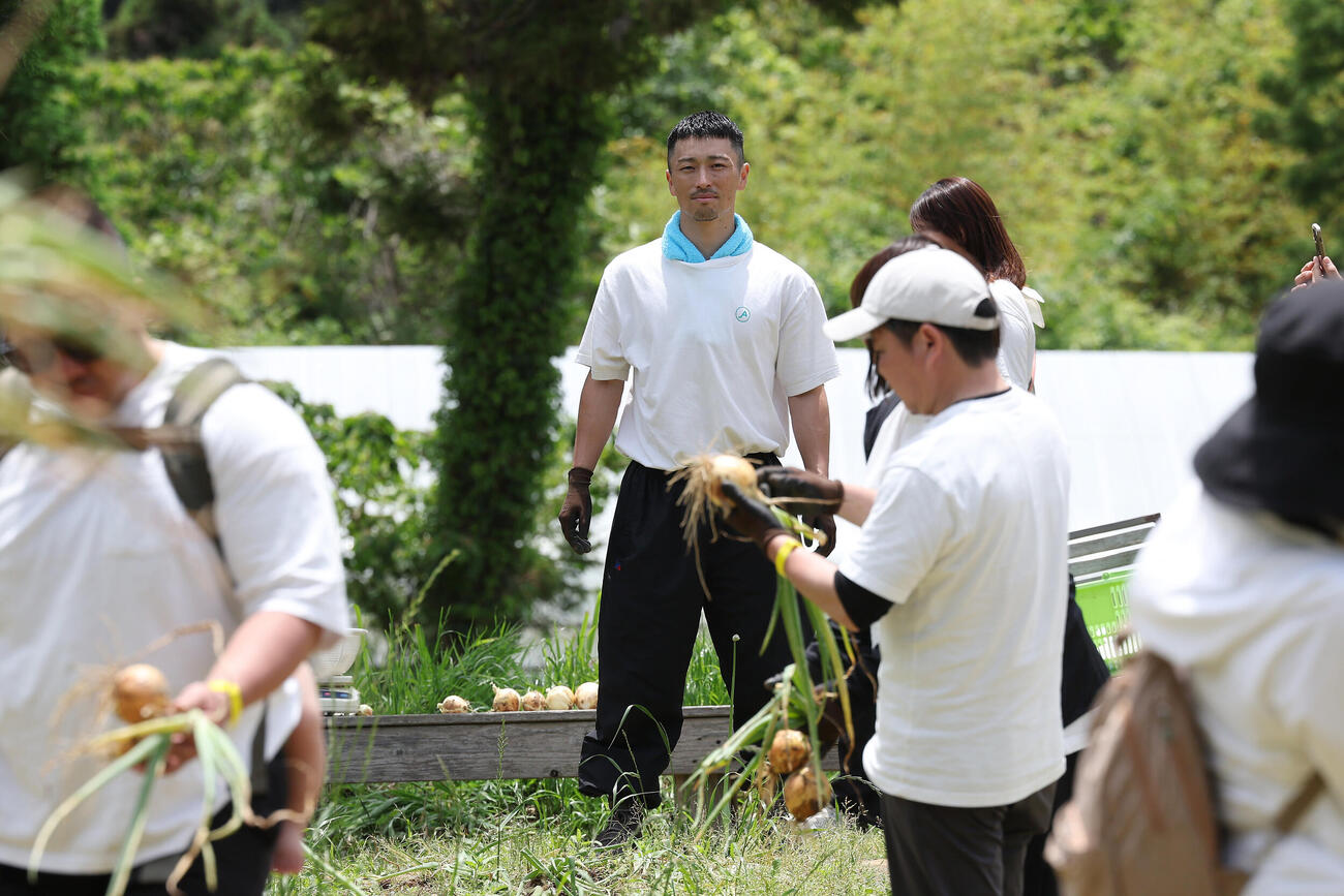 「元オリックス福田周平さんと！新玉ねぎ収穫＆”周平ファーム”お手伝い体験」　農作業でファンと交流する元オリックスの福田周平氏（中央）（撮影・前田充）＝2026年5月24日