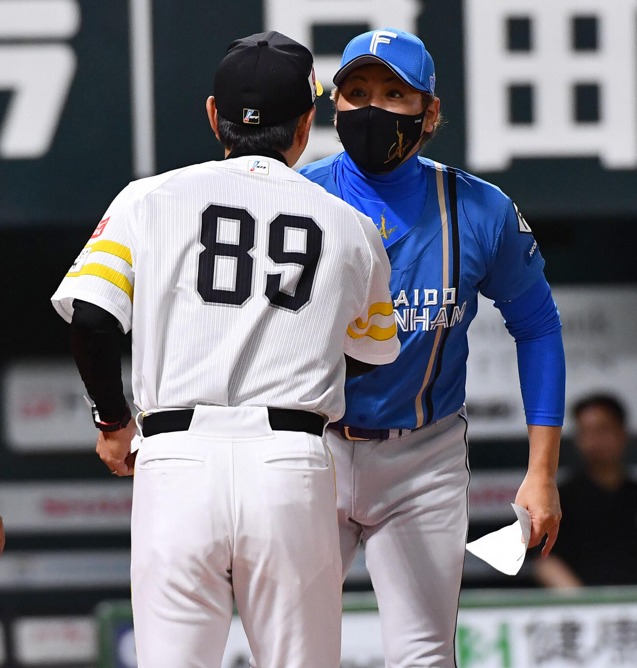 ソフトバンク対日本ハム　試合前、日本ハム新庄剛志監督（右）とメンバー表を交換し握手を交わすソフトバンク小久保裕紀監督（撮影・岩下翔太）