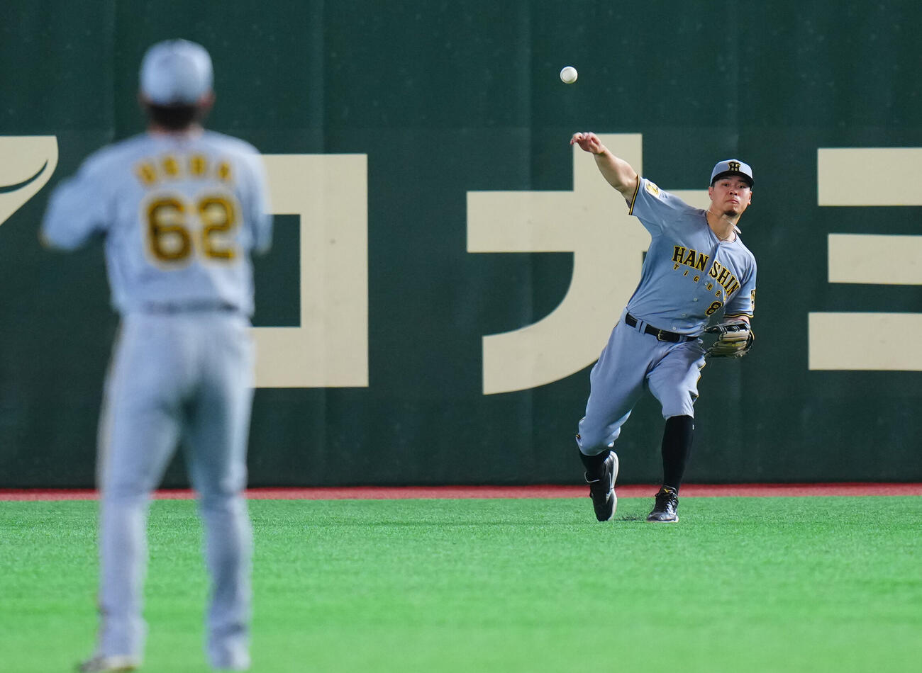 巨人対阪神　試合前、右翼でシートノックを行う阪神佐藤輝明（右）（撮影・垰建太）