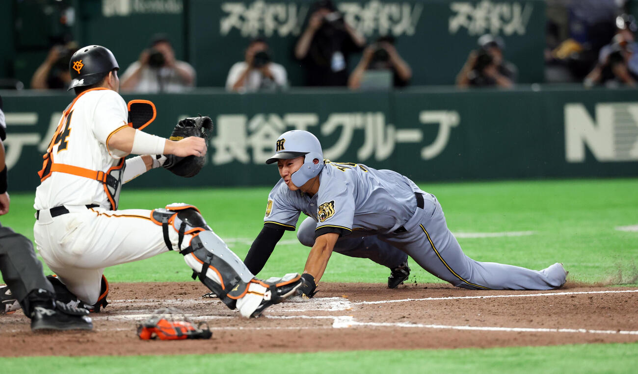巨人対阪神　7回表阪神2死一、二塁、佐藤輝明の適時打でヘッドスライティングで生還する立石正広。捕手大城卓三（撮影・浅見桂子）
