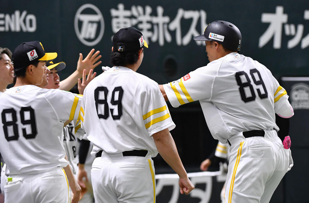 ソフトバンク対日本ハム　8回裏ソフトバンク1死一、三塁、勝ち越しの左犠飛を放った柳田悠岐（右）はナインとタッチを交わす（撮影・岩下翔太）