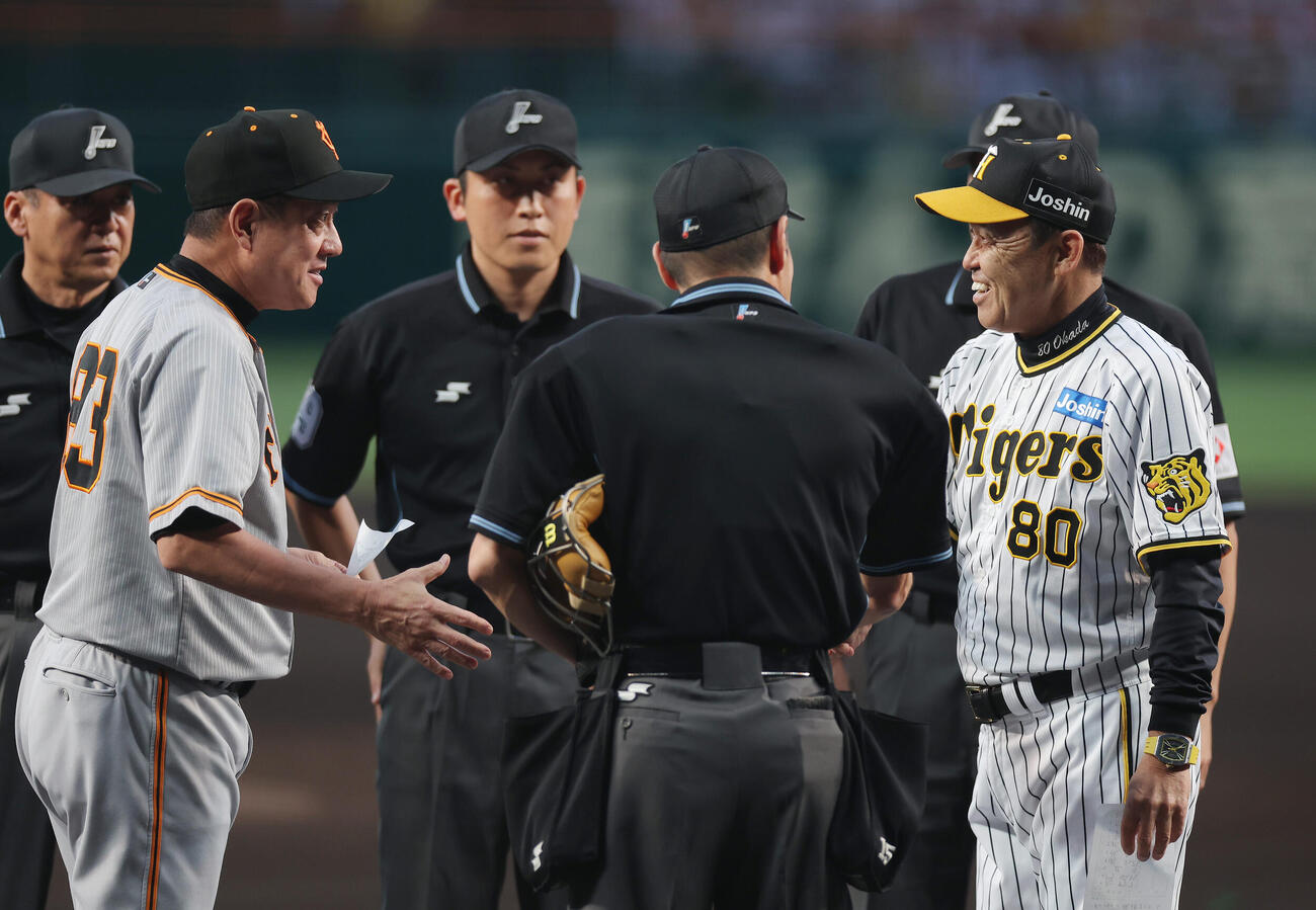 阪神対巨人　試合前、巨人原監督（左から2人目）と笑顔でメンバー表を交換する阪神岡田監督（右端）（2023年9月14日撮影）