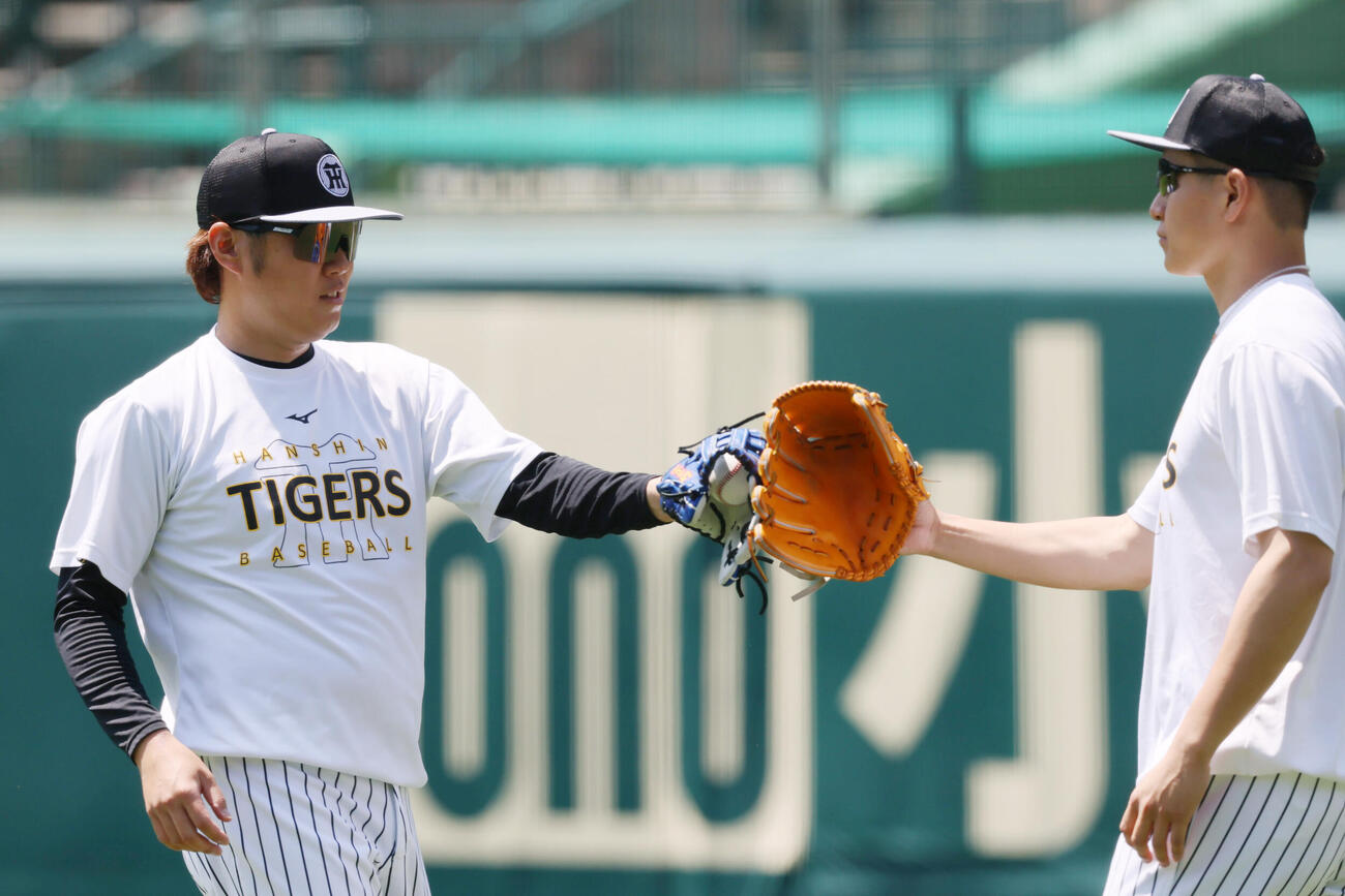 大竹耕太郎（右）とキャッチボールを終えグラブでタッチする阪神西勇輝（撮影・加藤哉）