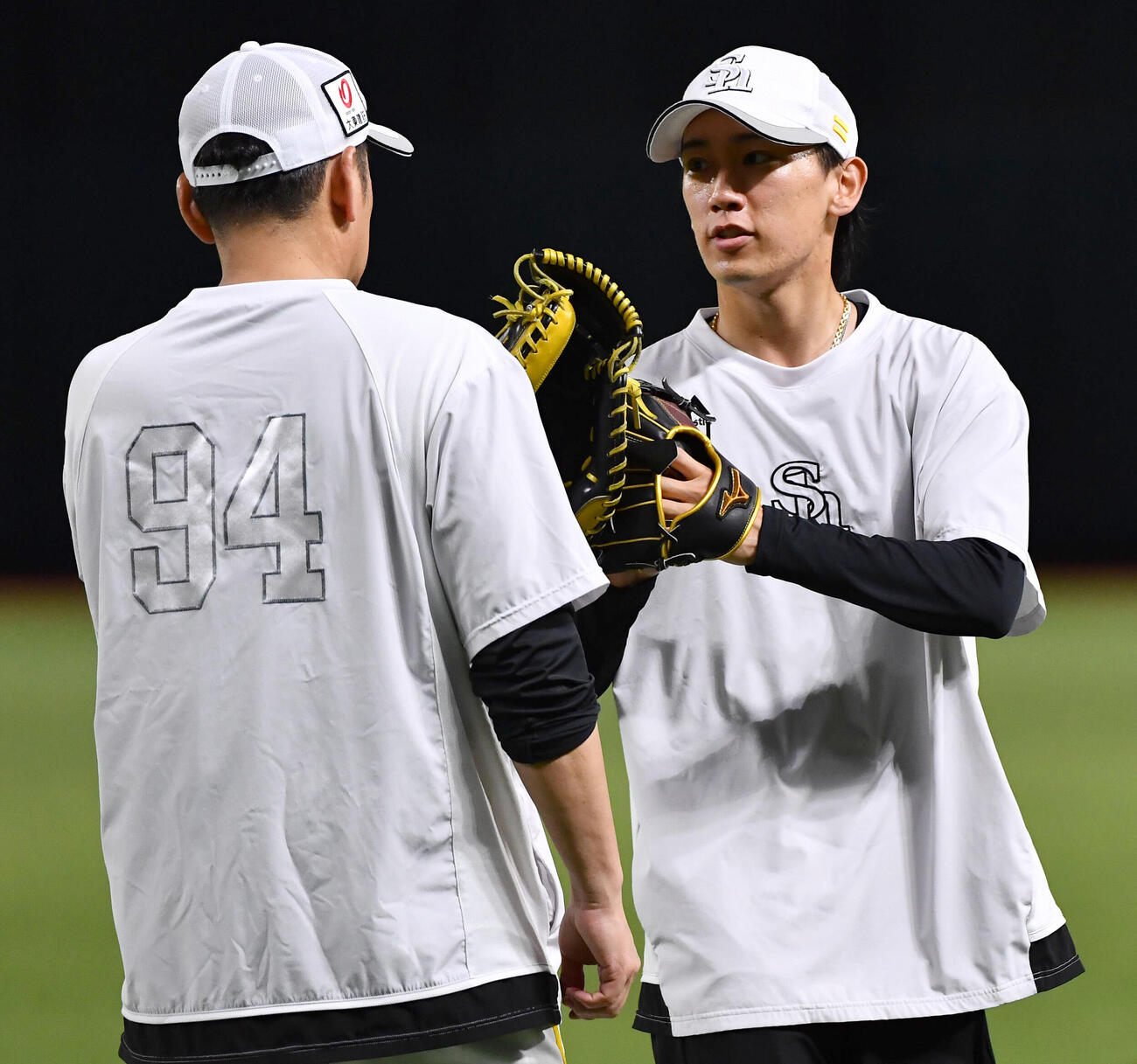 キャッチボールを終え、倉野信次投手チーフコーチ兼投手ヘッドコーディネーター（左）とタッチを交わすソフトバンク大津亮介（撮影・岩下翔太）