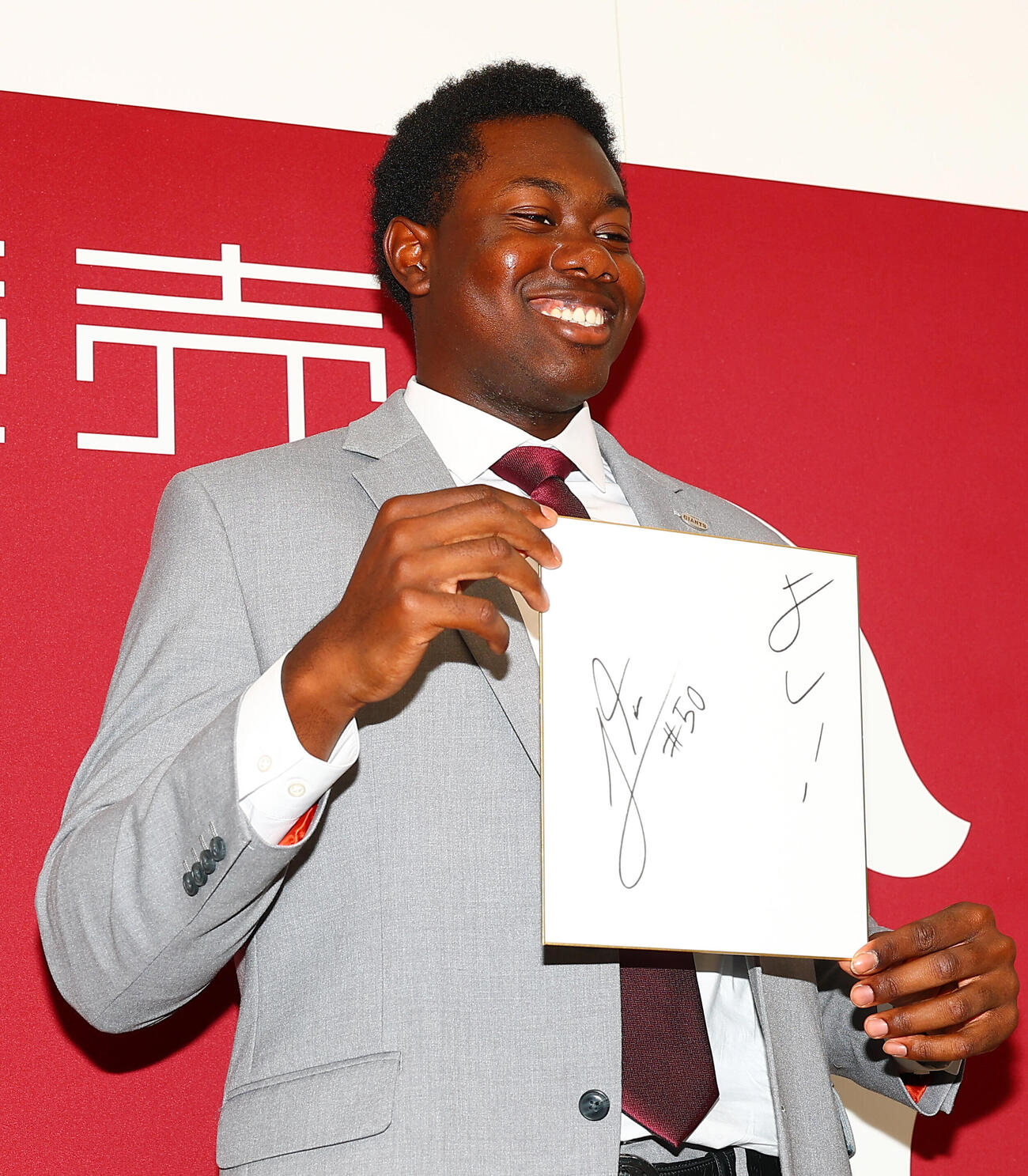 支配下登録会見で、色紙に好きな言葉「よし！」と記す巨人フリアン・ティマ（撮影・野上伸悟）