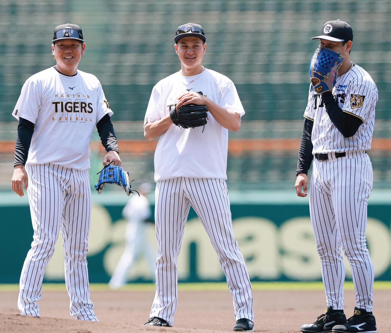 投内連係を前に笑顔を見せる、左から阪神西勇輝、大竹耕太郎、木下里都（撮影・上山淳一）