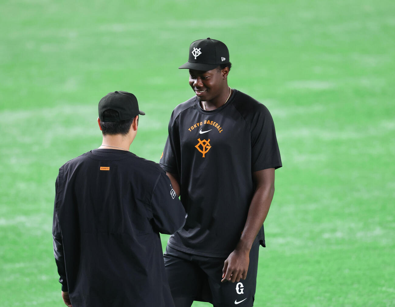巨人対ソフトバンク　支配下登録され岸田行倫（手前）と笑顔で握手する巨人フリアン・ティマ（撮影・増田悦実）