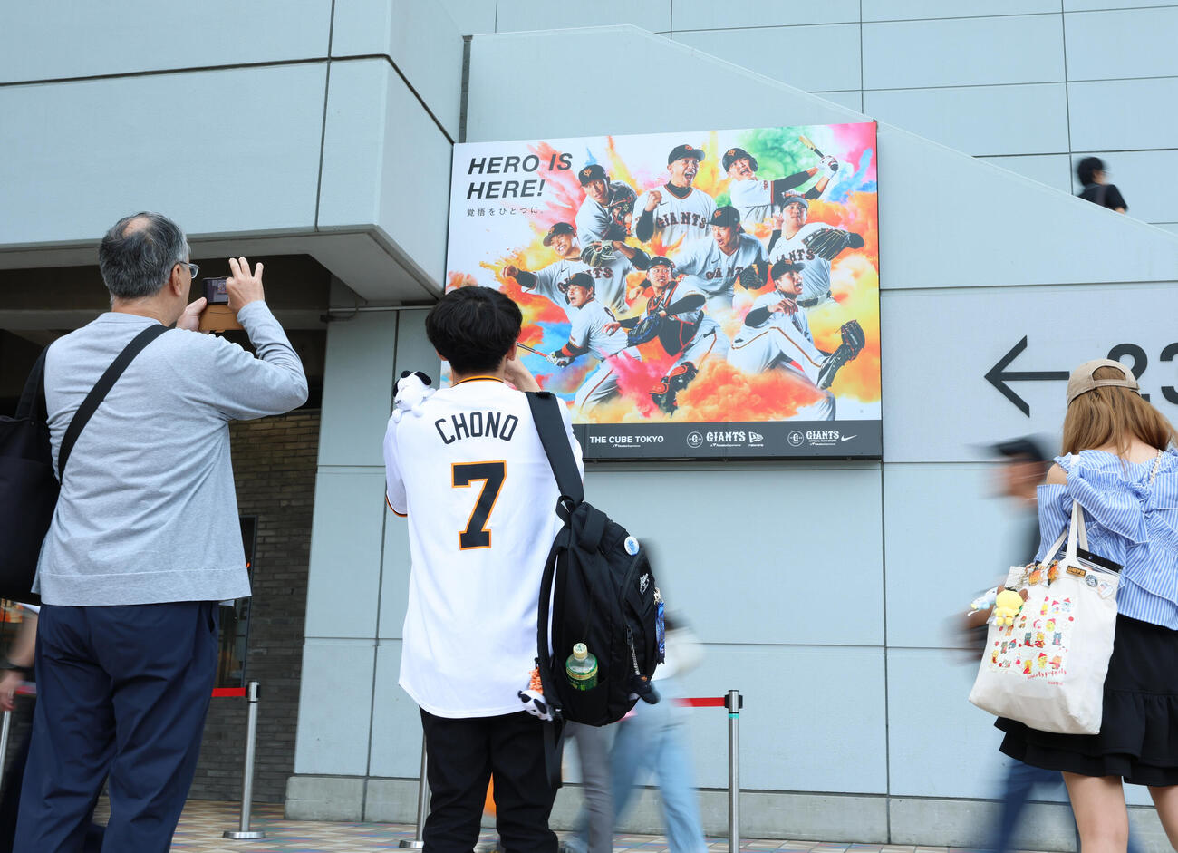 東京ドーム場外のポスターを撮影する巨人ファン（撮影・増田悦実）